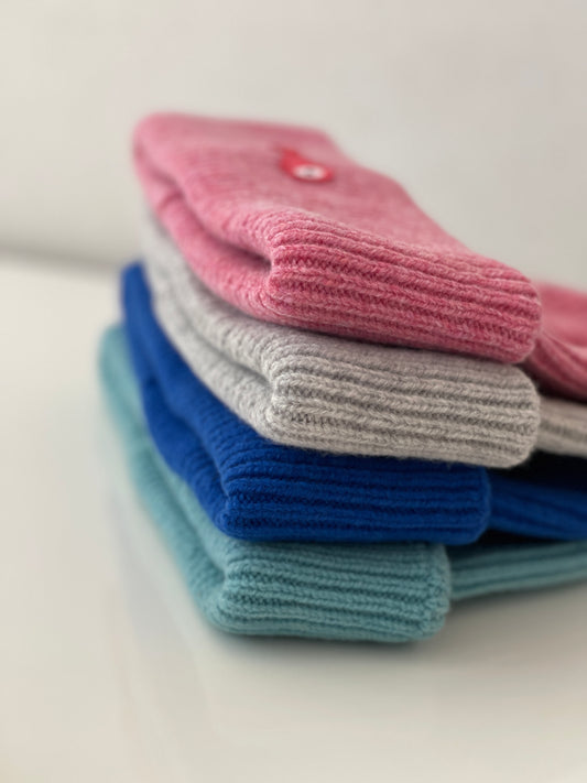 The collection of soft, colorful, and warm beanies crafted from luxurious lambswool yarn. Embrace comfort and style with these lovely accessories available in four captivating colors: Pink, Blue, Vibrant Mint, and Light Grey. Each beanie features a unique fish patch, adding a touch of charm and playfulness. Detail
