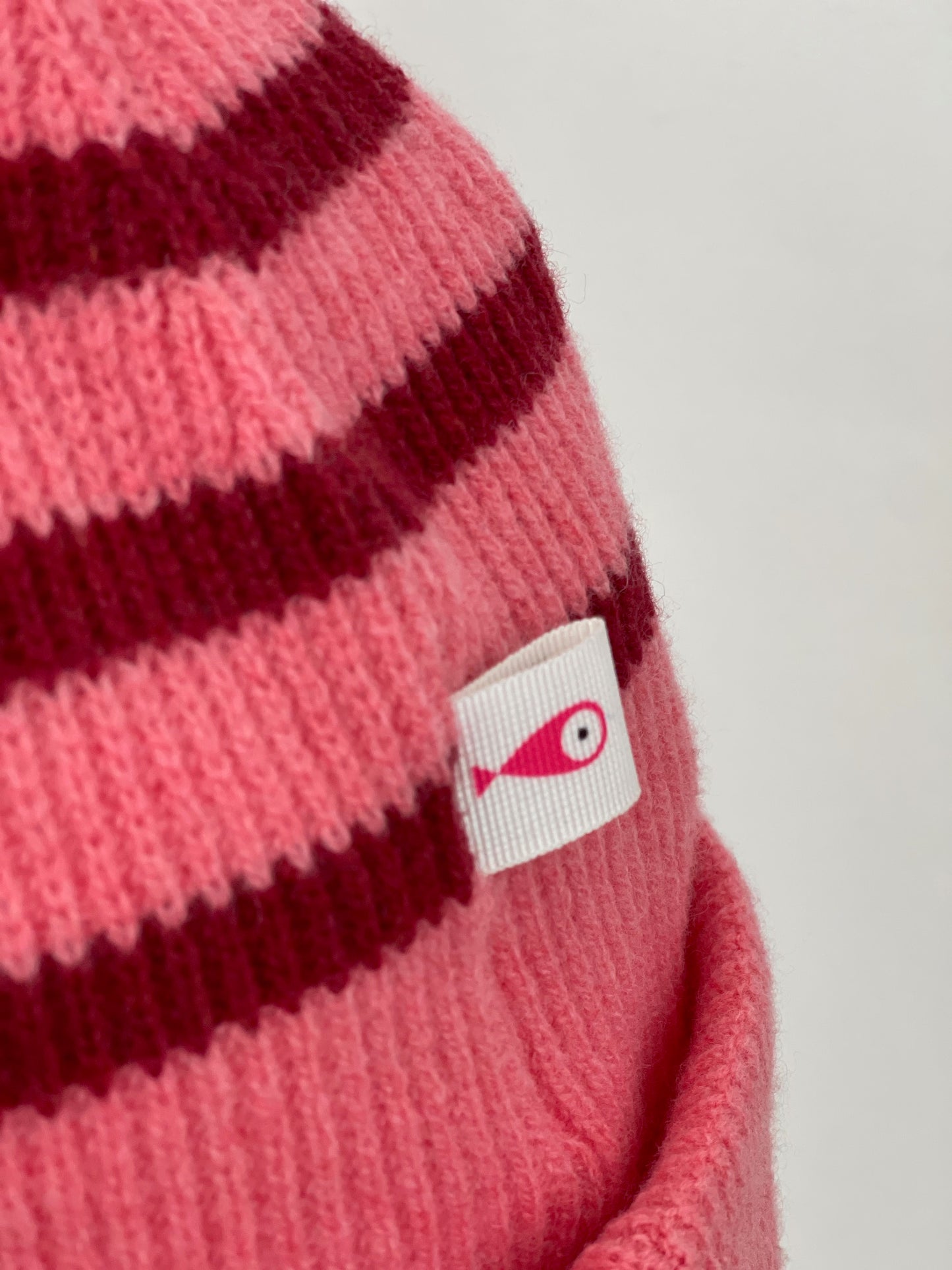 The collection of soft, colorful, and warm beanies crafted from luxurious lambswool yarn. Embrace comfort and style with these lovely accessories available in two lovely colors: Pink with red stripes and Navy blue with lighter blue stripes. Detail