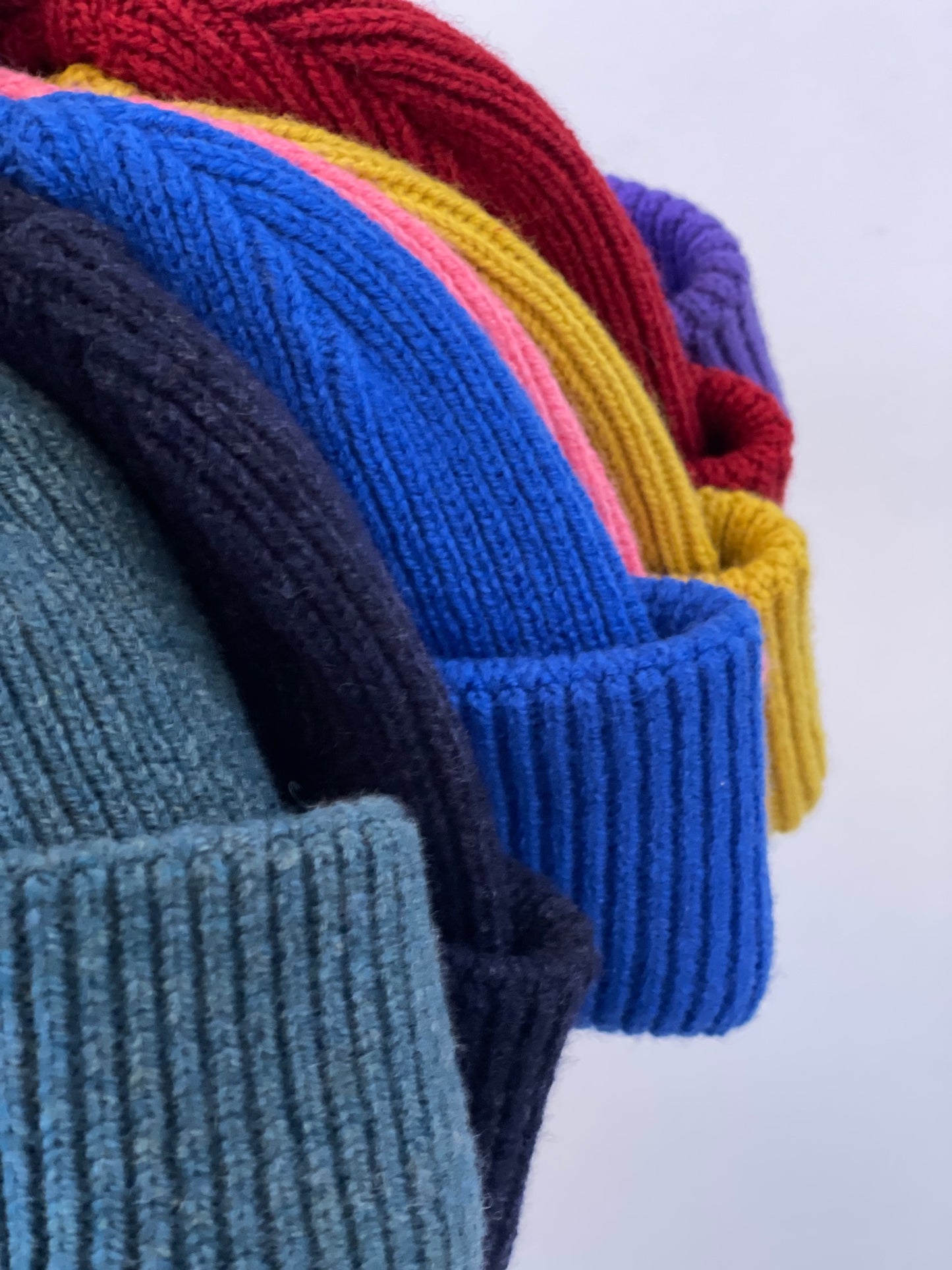 The soft, colorful, and warm kids/baby beanies crafted from luxurious lambswool yarn.   Adorned with a playful fish patch for a touch of playfulness. ( The Turquoise color features a distinctive back label. The front of the label showcases a pink fish, turn the label around, and you'll find our logo discreetly placed on the back )  Vibrant palette of seven colors – Yellow, Purple, Red, Blue, Pink, Navy Blue and Turquoise. Detail