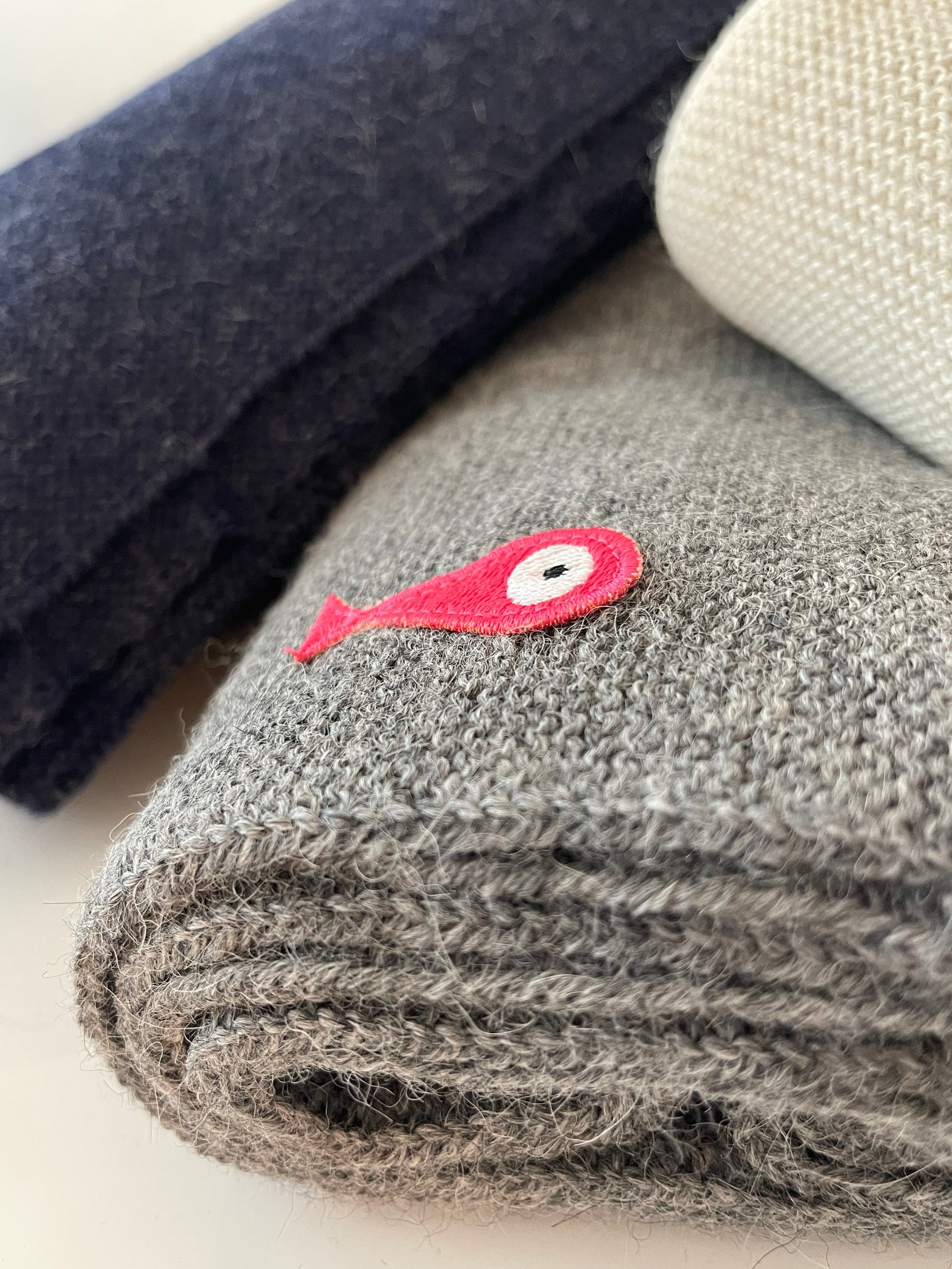 Soft, luxuriously and cozy scarfs. Knitted from a superfine alpaca yarn. Classic scarfs with a lovely feeling.  Colours : creme white, navy blue and grey  Material: 100% alpaca  Patch: pink fish  Sizes:  Navy Blue color : 2.20 cm x 22 cm  Grey color : 2.20 cm x 22 cm   Creme White color :  200 cm x 22 cm Detail Smart casual dress code