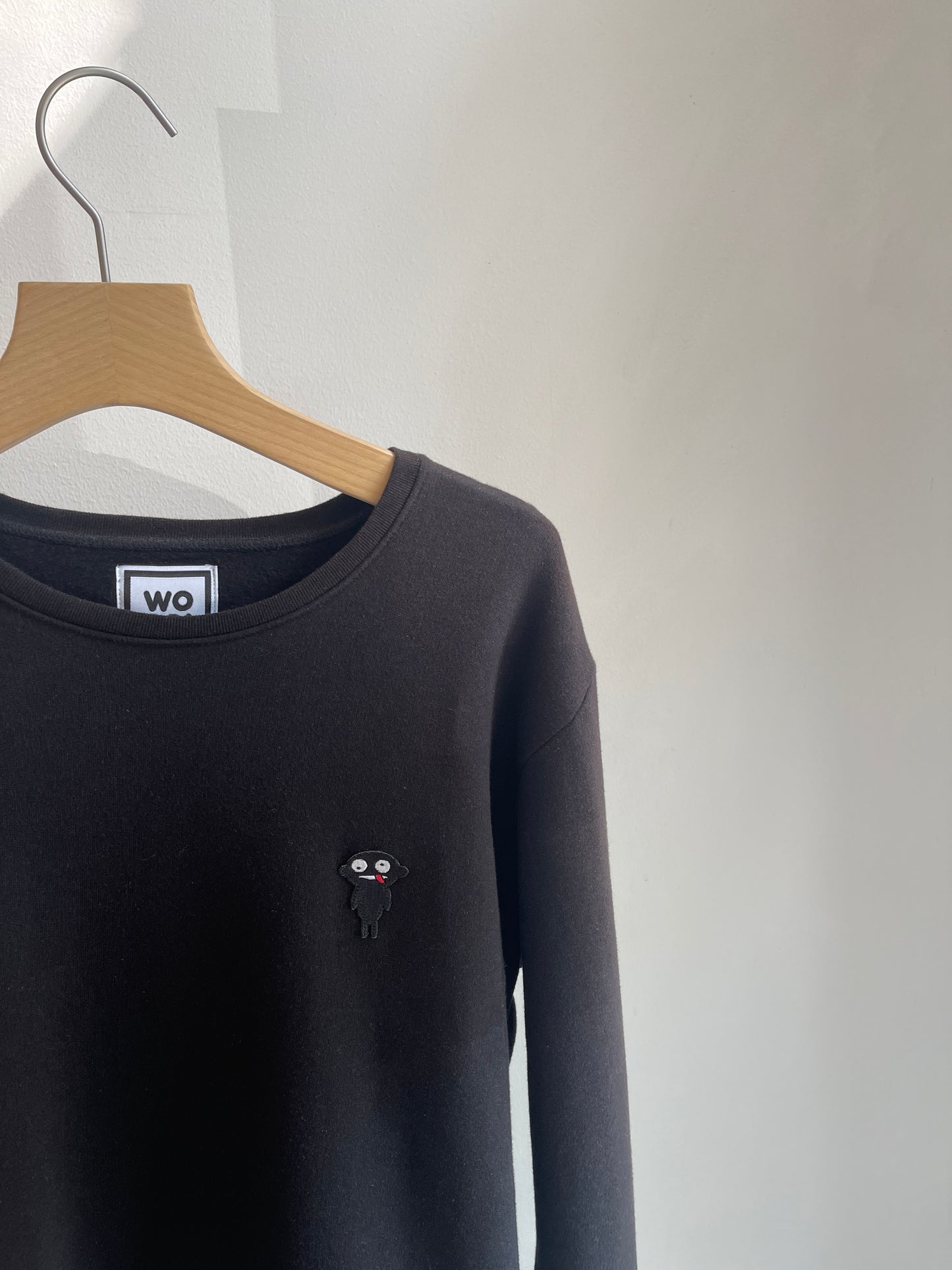 Beautifully crafted crewneck, with a classic, raglan-sleeved cut.  Crafted from 100 % superfine cotton.. Raglan sleeves, ribbed trims and with teddy character patch.  Colour: black Patch: teddy character