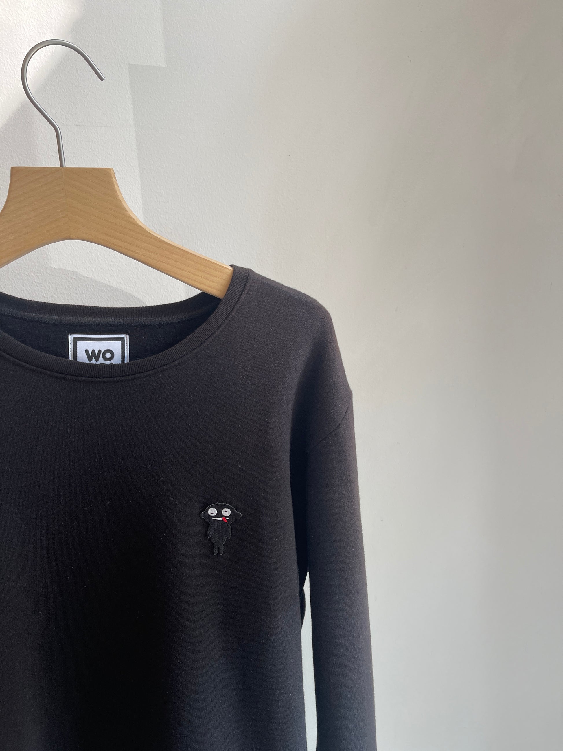 Beautifully crafted crewneck, with a classic, raglan-sleeved cut.  Crafted from 100 % superfine cotton.. Raglan sleeves, ribbed trims and with teddy character patch.  Colour: black Patch: teddy character
