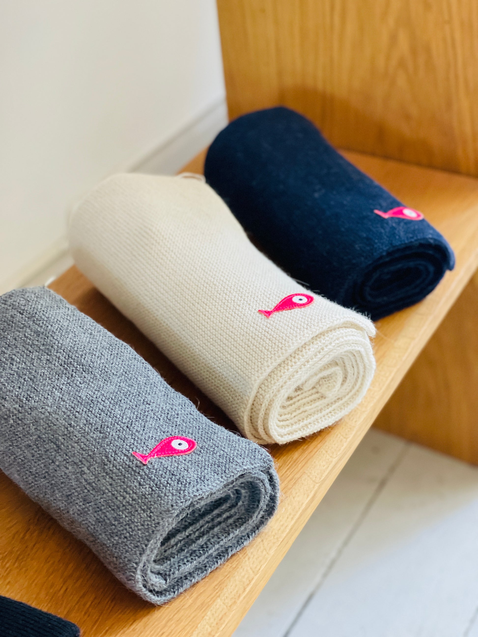 Soft, luxuriously and cozy scarfs. Knitted from a superfine alpaca yarn. Classic scarfs with a lovely feeling.  Colours : creme white, navy blue and grey  Material: 100% alpaca  Patch: pink fish  Sizes:  Navy Blue color : 2.20 cm x 22 cm  Grey color : 2.20 cm x 22 cm   Creme White color :  200 cm x 22 cm Side Front Smart casual dress code