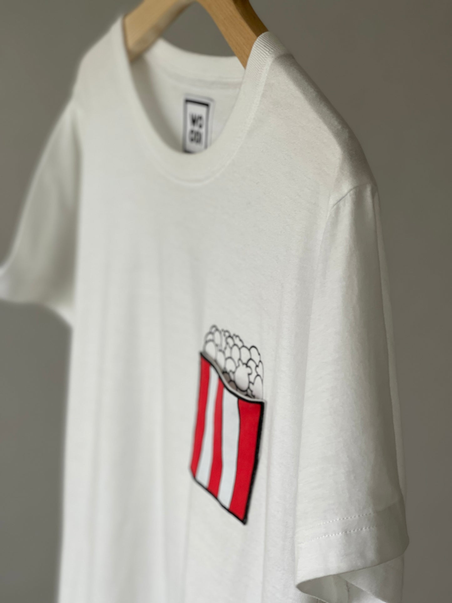 Regular fitted crewneck t-shirt. Cut from 100% superfine cotton, the shape makes it ideal for any occasion. The perfect piece for layering or wearing on its own.  Colour: white Pocket: front pocket with printed popcorns inside Material: 100%  cotton. Front Side