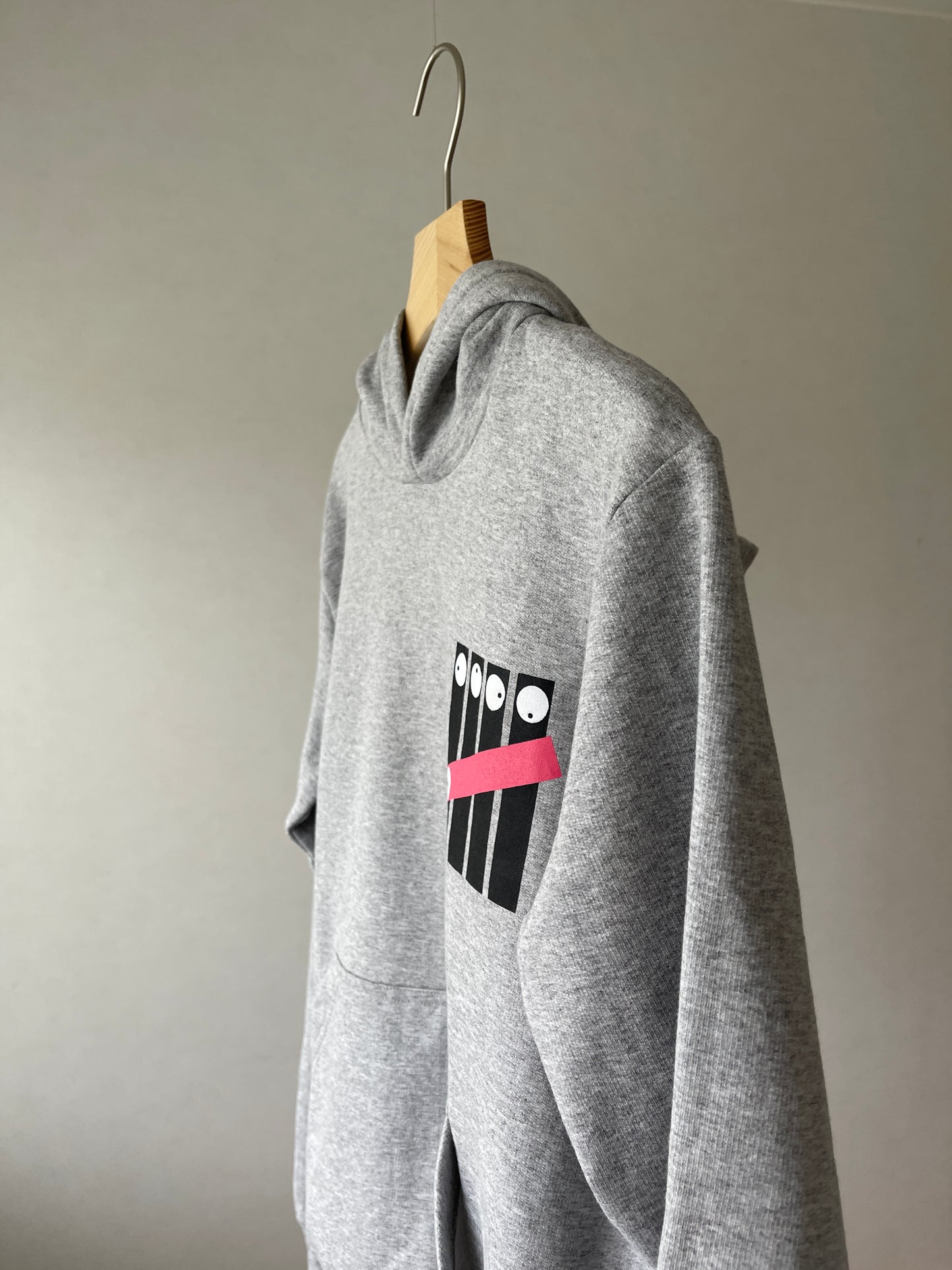 Super cozy hoodie with a kangaroo pocket in the front with no drawstrings. Crafted from comfortable cotton and polyester blend. Raglan sleeves, ribbed trims. The pieces have a fish fingers print in the front.  Colour: light grey Material: 100% cotton Front Side