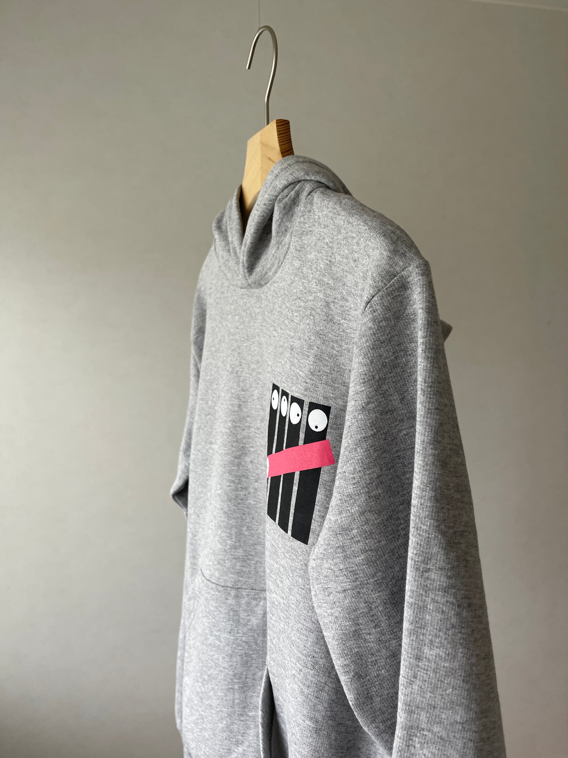 Super cozy hoodie with a kangaroo pocket in the front with no drawstrings. Crafted from comfortable cotton and polyester blend. Raglan sleeves, ribbed trims. The pieces have a fish fingers print in the front.  Colour: light grey Material: 100% cotton Front Side