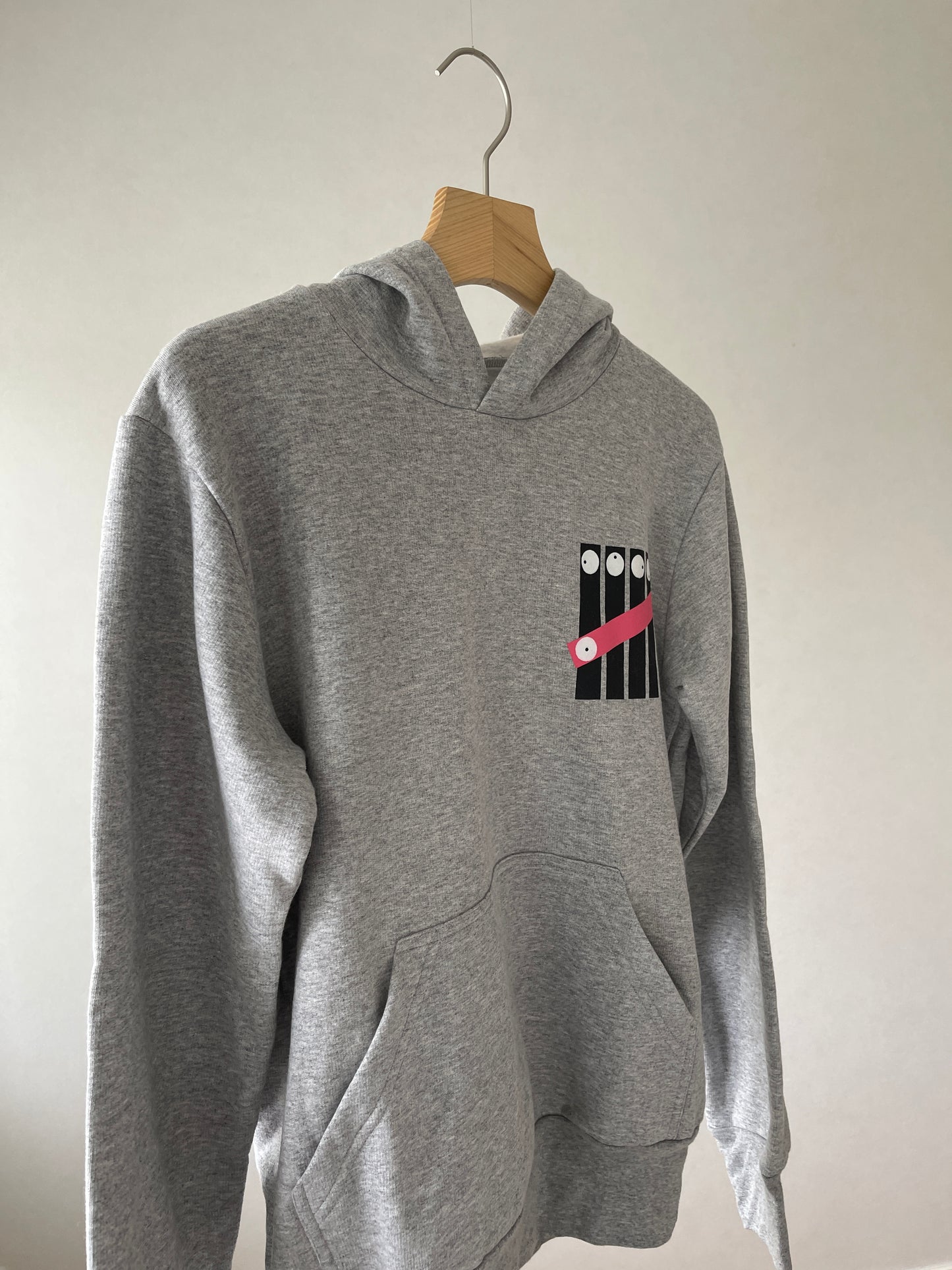 Super cozy hoodie with a kangaroo pocket in the front with no drawstrings. Crafted from comfortable cotton and polyester blend. Raglan sleeves, ribbed trims. The pieces have a fish fingers print in the front.  Colour: light grey Material: 100% cotton Front Side