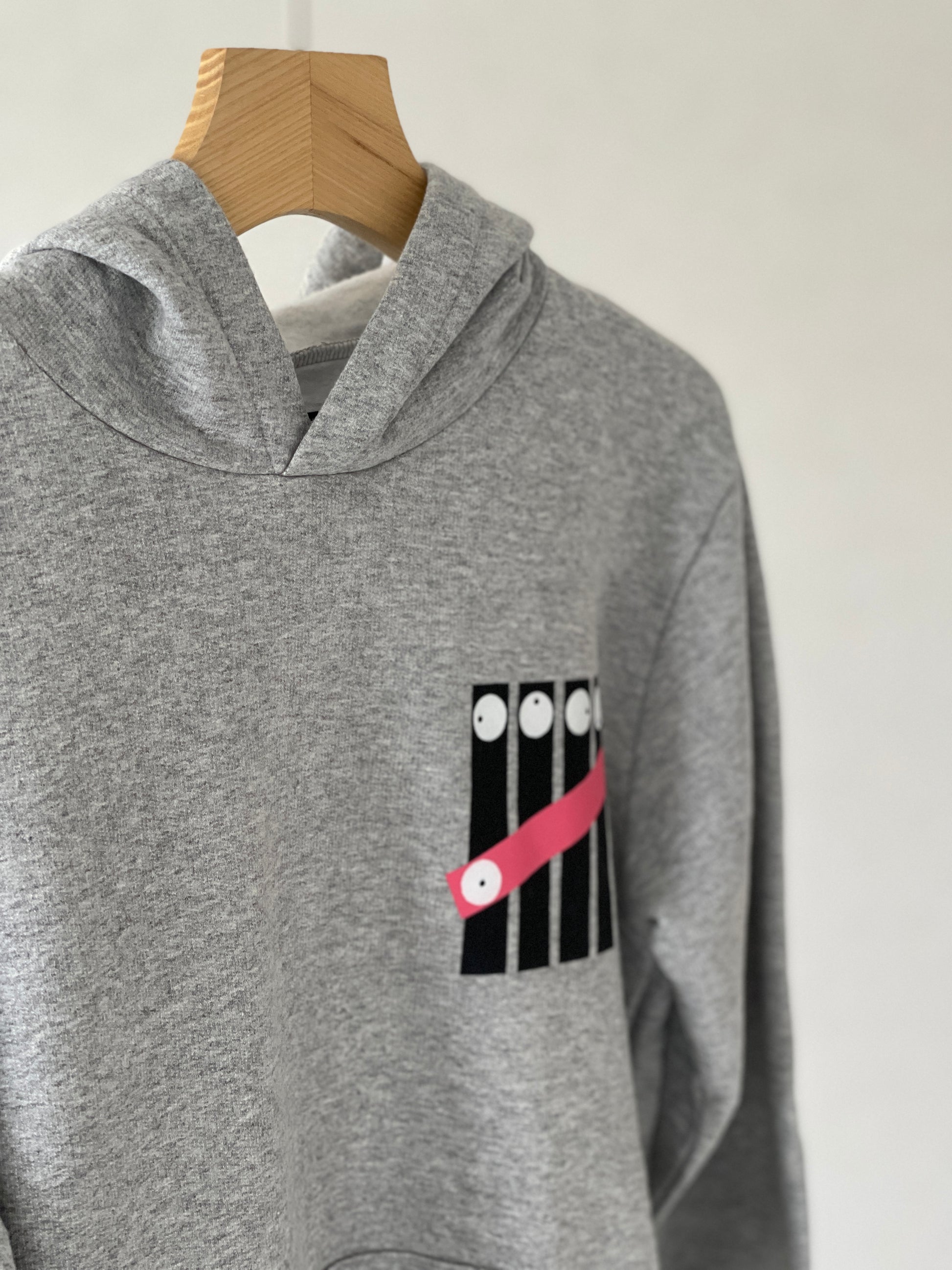 Super cozy hoodie with a kangaroo pocket in the front with no drawstrings. Crafted from comfortable cotton and polyester blend. Raglan sleeves, ribbed trims. The pieces have a fish fingers print in the front.  Colour: light grey Material: 100% cotton Front Side