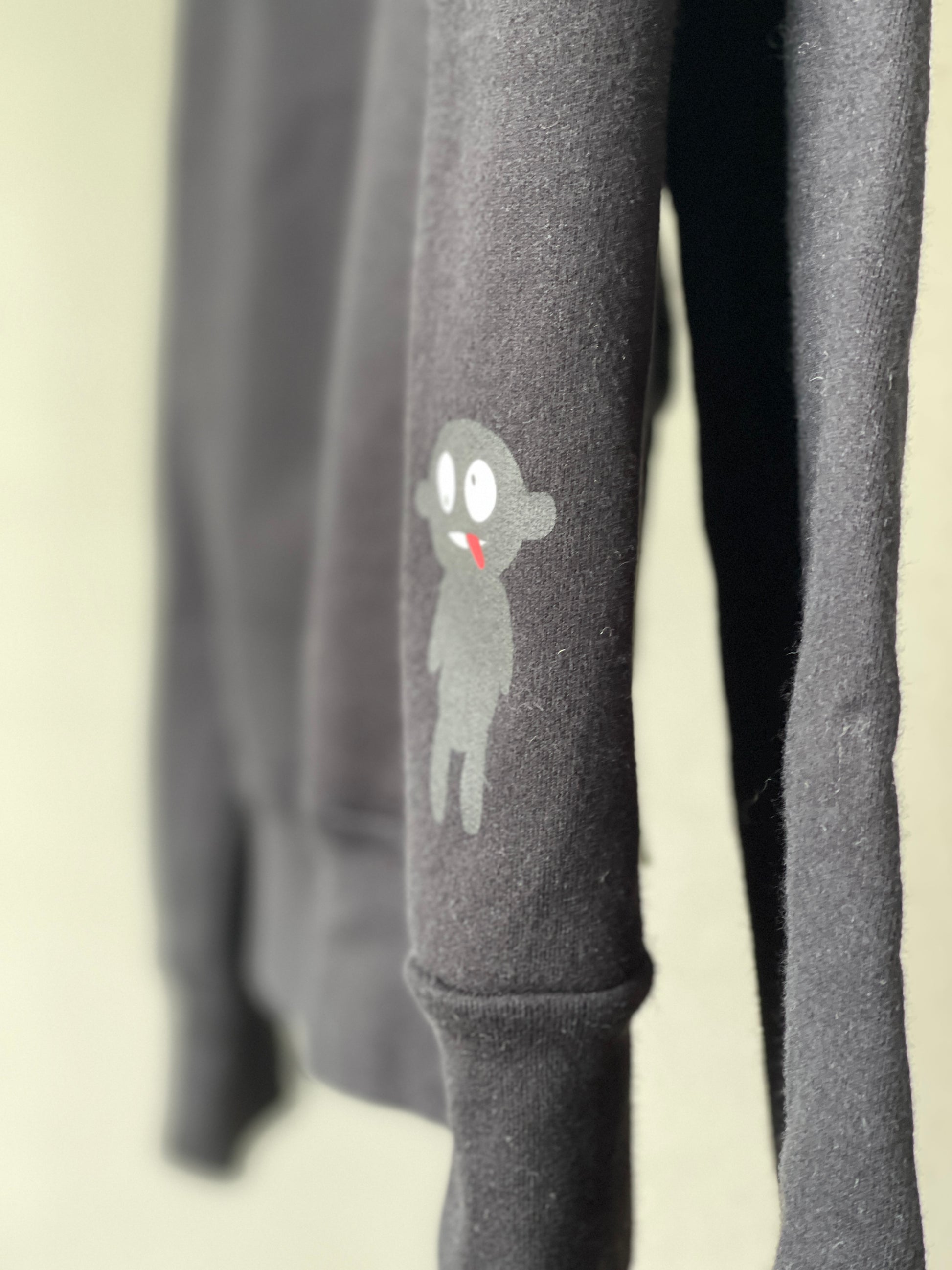 Super cozy Hoodie with a kangaroo pocket in the front with no drawstrings. Front zip closure. Crafted from 100 % superfine cotton. Raglan sleeves, ribbed trims. The pieces have a WOODI logo on front and a teddy character print on back bottom corner.  Colour: black Material: 100% cotton