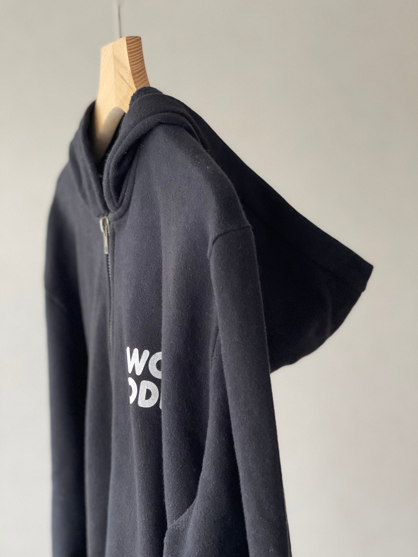 Super cozy Hoodie with a kangaroo pocket in the front with no drawstrings. Front zip closure. Crafted from 100 % superfine cotton. Raglan sleeves, ribbed trims. The pieces have a WOODI logo on front and a teddy character print on back bottom corner.  Colour: black Material: 100% cotton