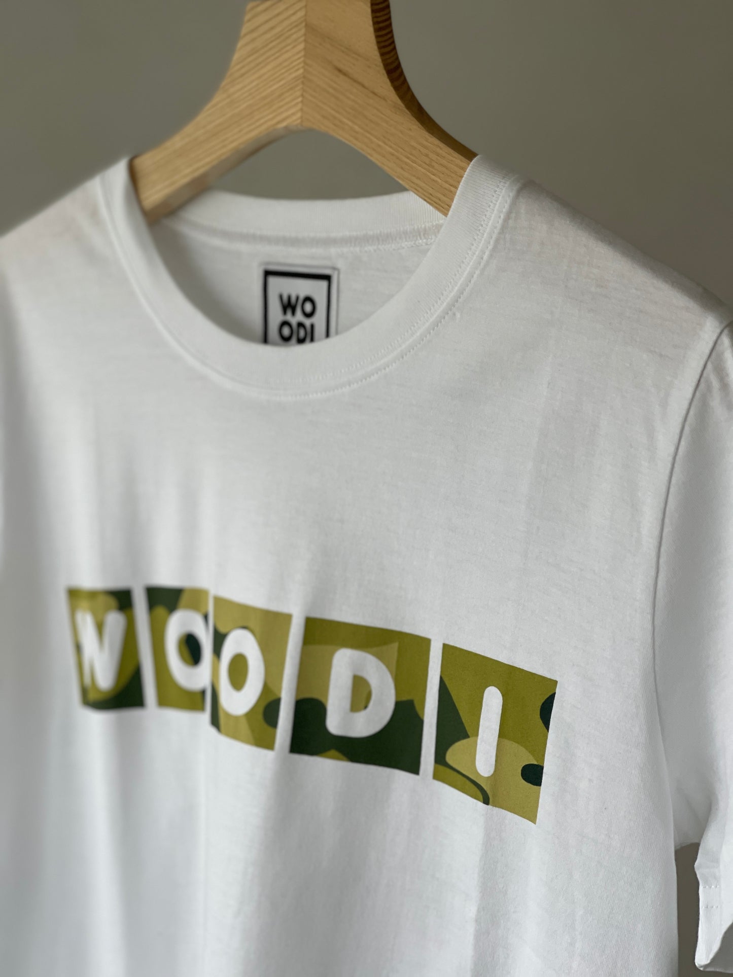 Regular fitted crewneck t-shirt. Cut from 100% superfine cotton, the shape makes it ideal for any occasion. The perfect piece for layering or wearing on its own.  Colour: white Print: WOODI text green print Material: 100%  cotton