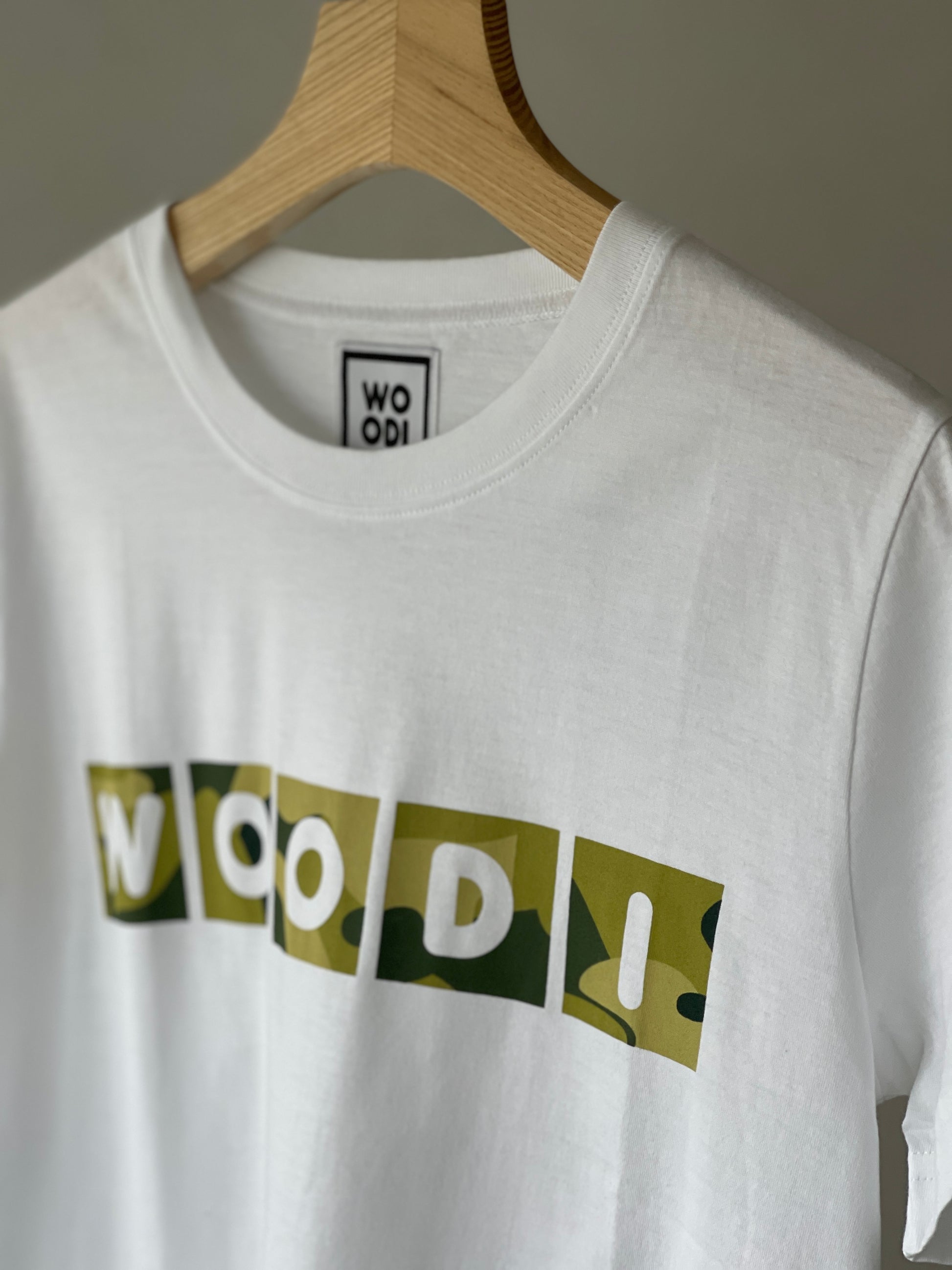 Regular fitted crewneck t-shirt. Cut from 100% superfine cotton, the shape makes it ideal for any occasion. The perfect piece for layering or wearing on its own.  Colour: white Print: WOODI text green print Material: 100%  cotton