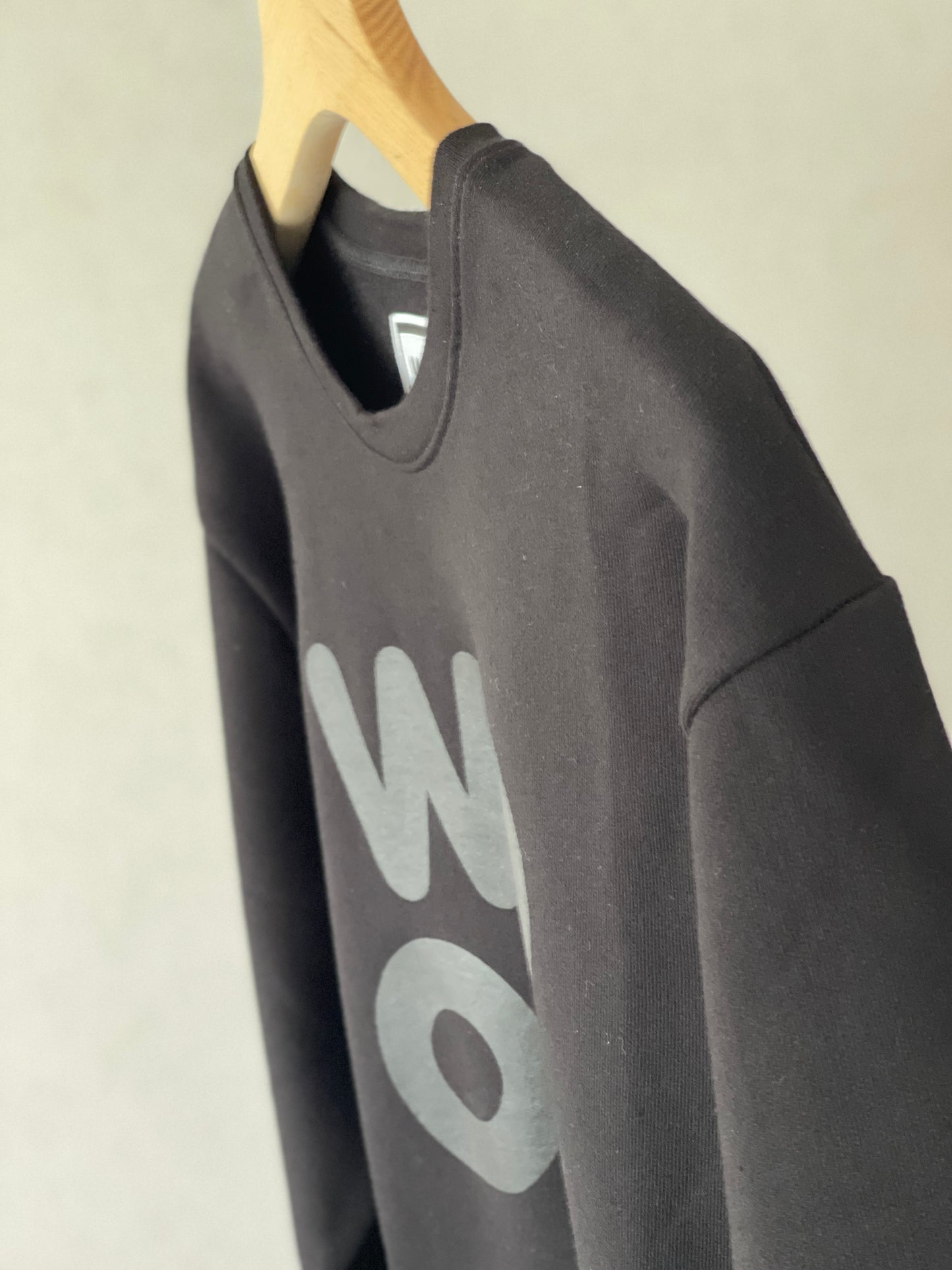Beautifully crafted crewneck, with a classic, raglan-sleeved cut. Crafted from 100 % superfine cotton. Raglan sleeves, ribbed trims and with a double printed WOODI logo on the chest and a teddy character print on the back of the neck.  Colour: black  Material: 100% cotton