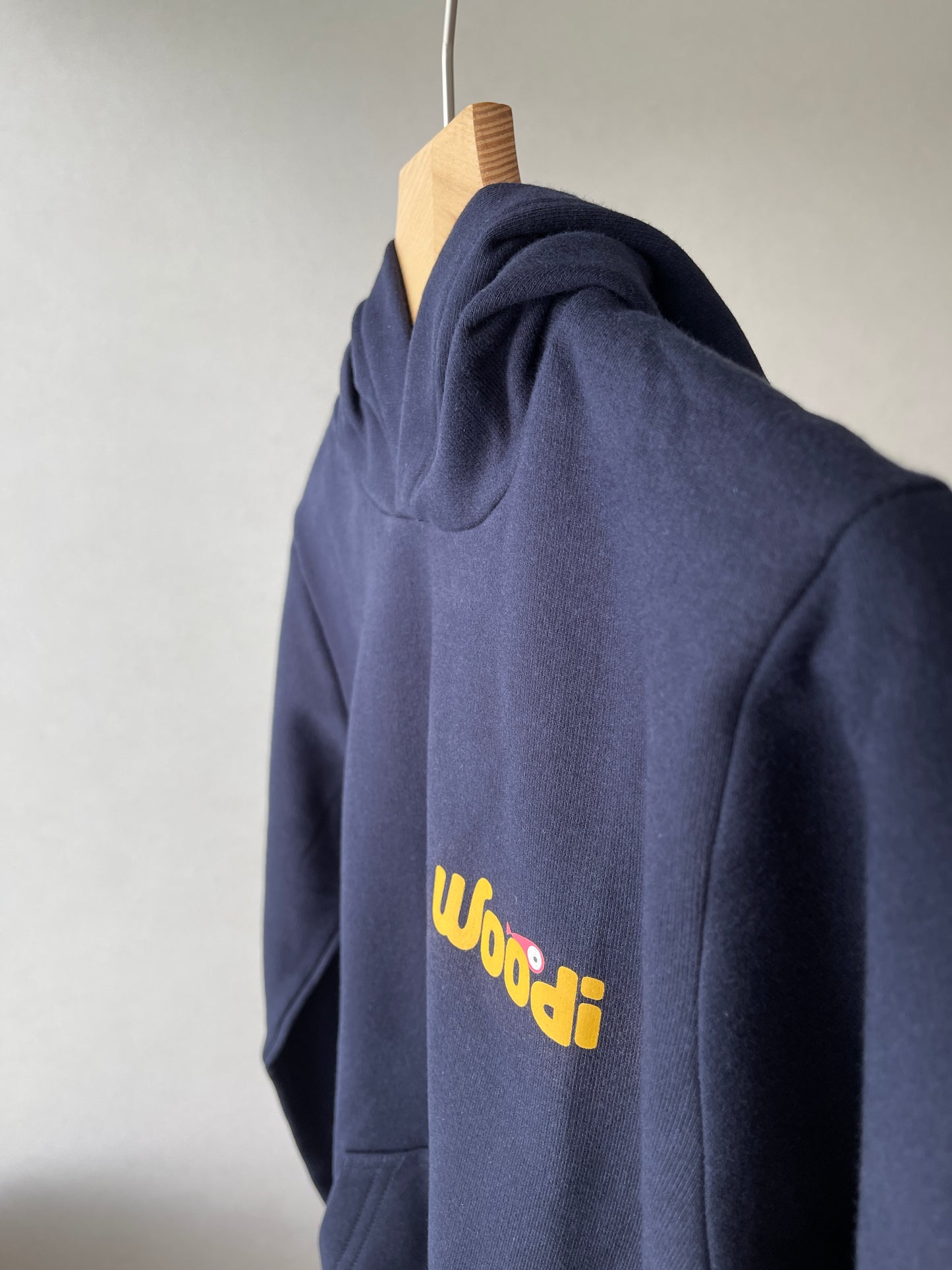 Super cozy hoodie with a kangaroo pocket in the front with no drawstrings. Crafted from the finest cotton. Raglan sleeves, ribbed trims. The pieces have a WOODI swirl text and fish print in the front.  Colour: navy blue Material: 100% cotton