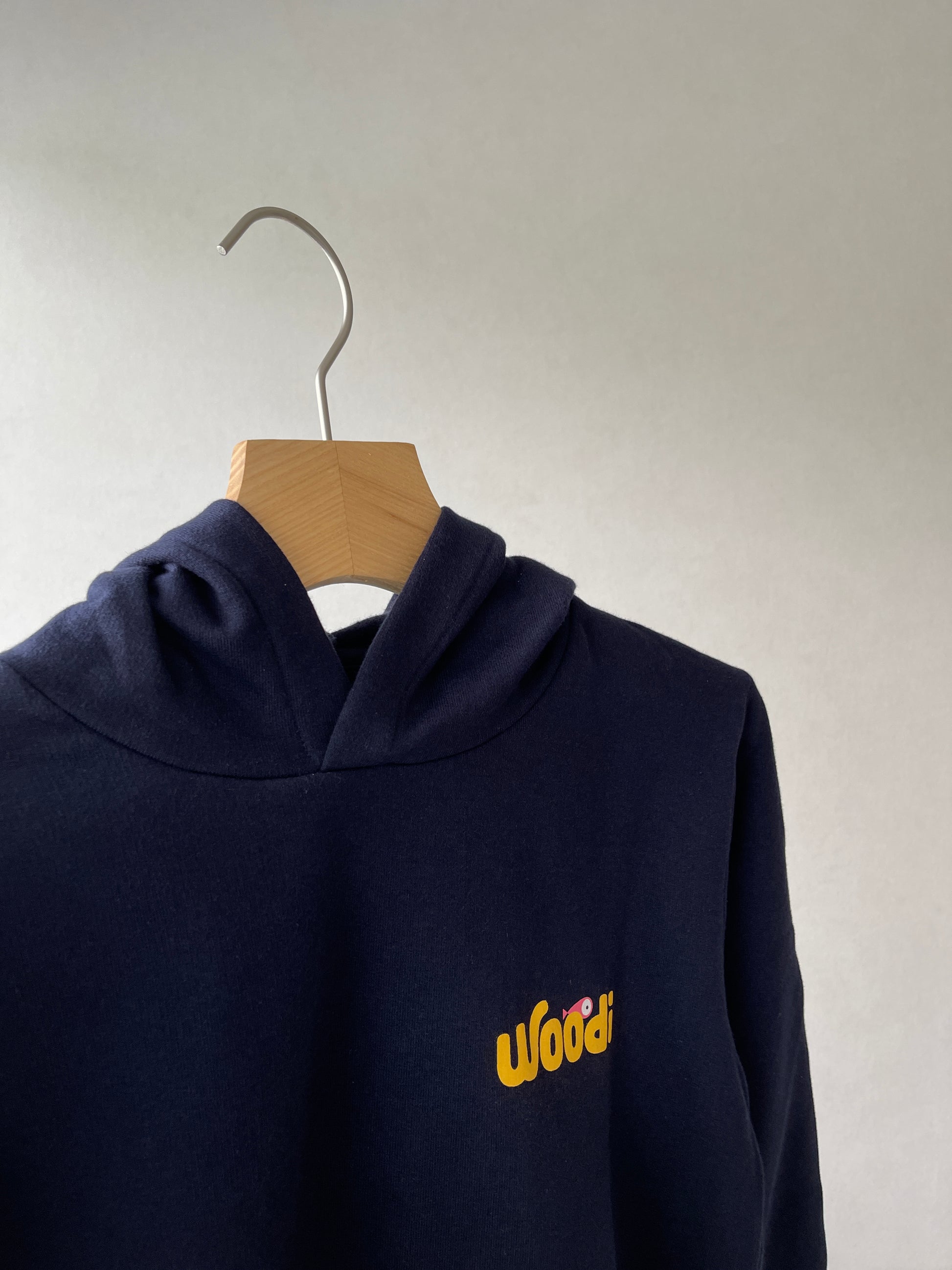 Super cozy hoodie with a kangaroo pocket in the front with no drawstrings. Crafted from the finest cotton. Raglan sleeves, ribbed trims. The pieces have a WOODI swirl text and fish print in the front.  Colour: navy blue Material: 100% cotton