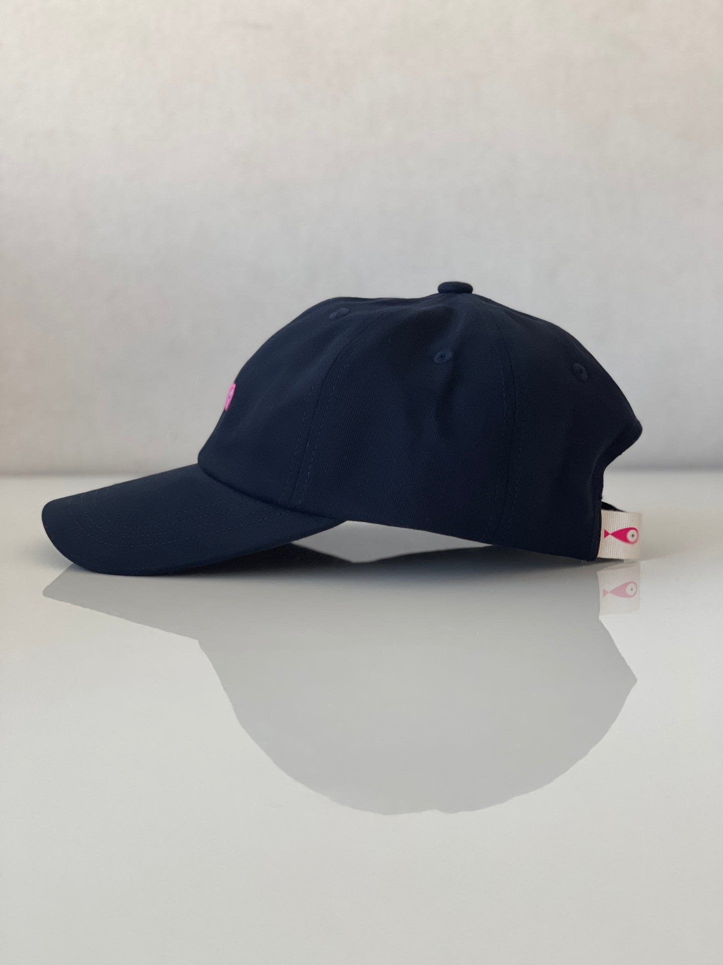 Cap Classic "Fish"  Slightly curved brim  Fish embroidery on front  Label on the back  Buckle to adjust the fit  5 Colors available : Navy Blue, Black, Pink, Olive Green and Light Beige  100 % cotton  One size  Profile Side
