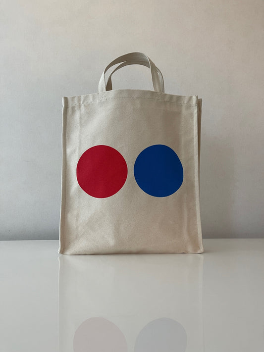 Lovely tote bag crafted from a organic cotton canvas. Short handles. A great companion that will never let you down. Perfect for the beach, school, shopping and weekend trips. Red & blue dots on both sides of the tote bag. WOODI logo print inside Size : 39 cm x 35 cm