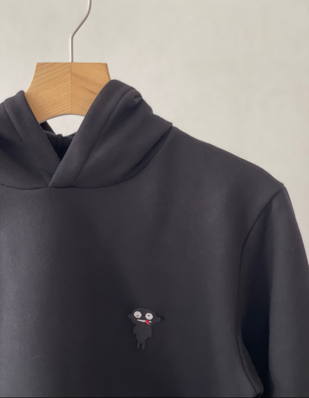 Super cozy hoodie with a kangaroo pocket in the front with no drawstrings. Crafted from comfortable and the finest cotton. Raglan sleeves, ribbed trims and with teddy character patch.  Colour: black Patch: teddy character